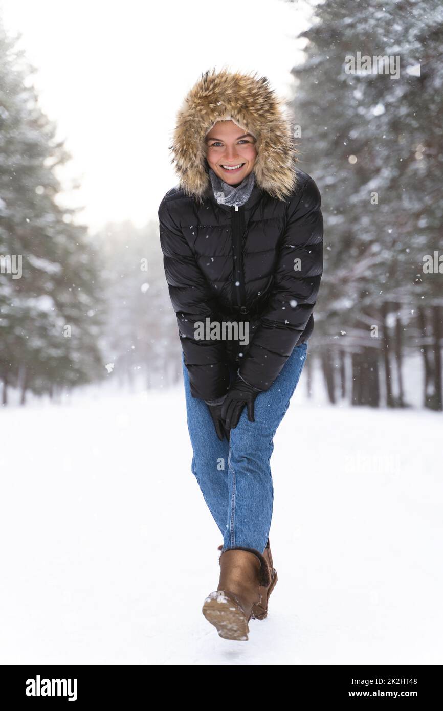 Jeune et joyeuse femme appréciant la marche pendant la belle journée d'hiver Banque D'Images