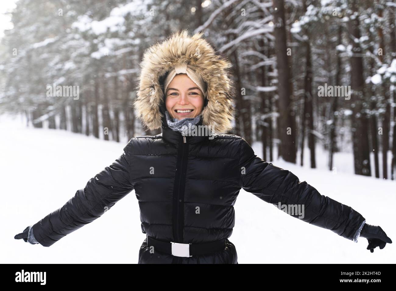 Jeune et joyeuse femme appréciant la marche pendant la belle journée d'hiver Banque D'Images