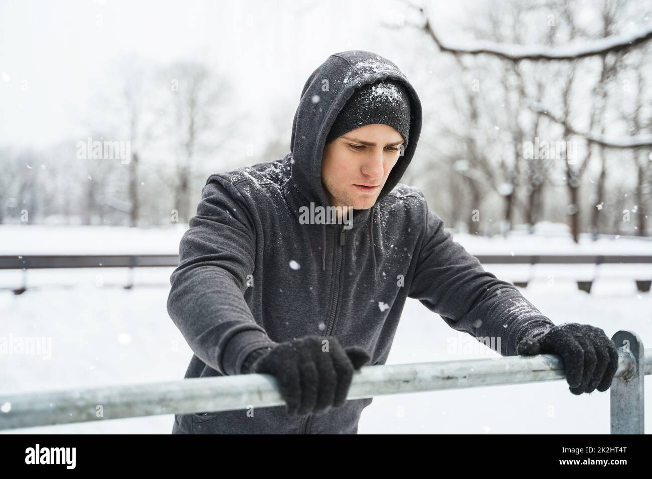 Homme athlétique qui fait des retouches pendant son entraînement d'hiver à la calisthénique Banque D'Images