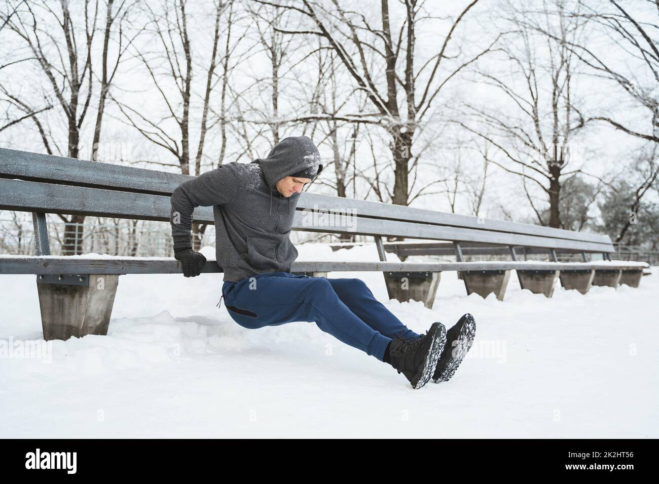 Homme athlétique qui fait des retouches pendant son entraînement d'hiver à la calisthénique Banque D'Images
