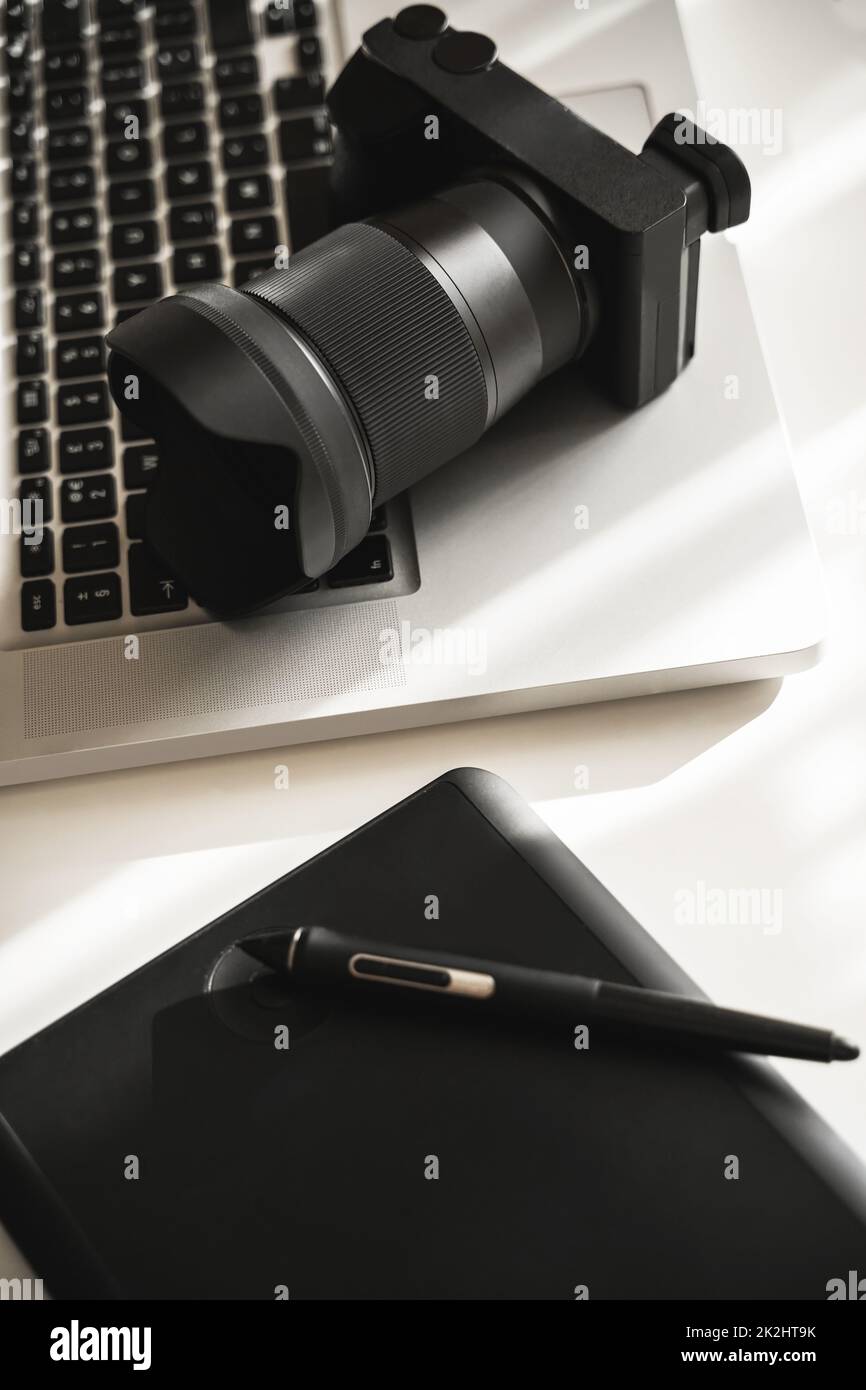 Le lieu de travail du photographe avec un appareil photo sans miroir, un ordinateur portable et une tablette graphique Banque D'Images
