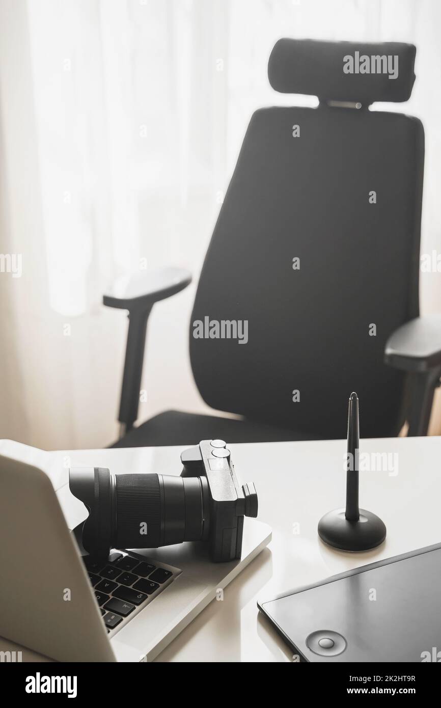 Le lieu de travail du photographe avec un appareil photo sans miroir, un ordinateur portable et une tablette graphique Banque D'Images