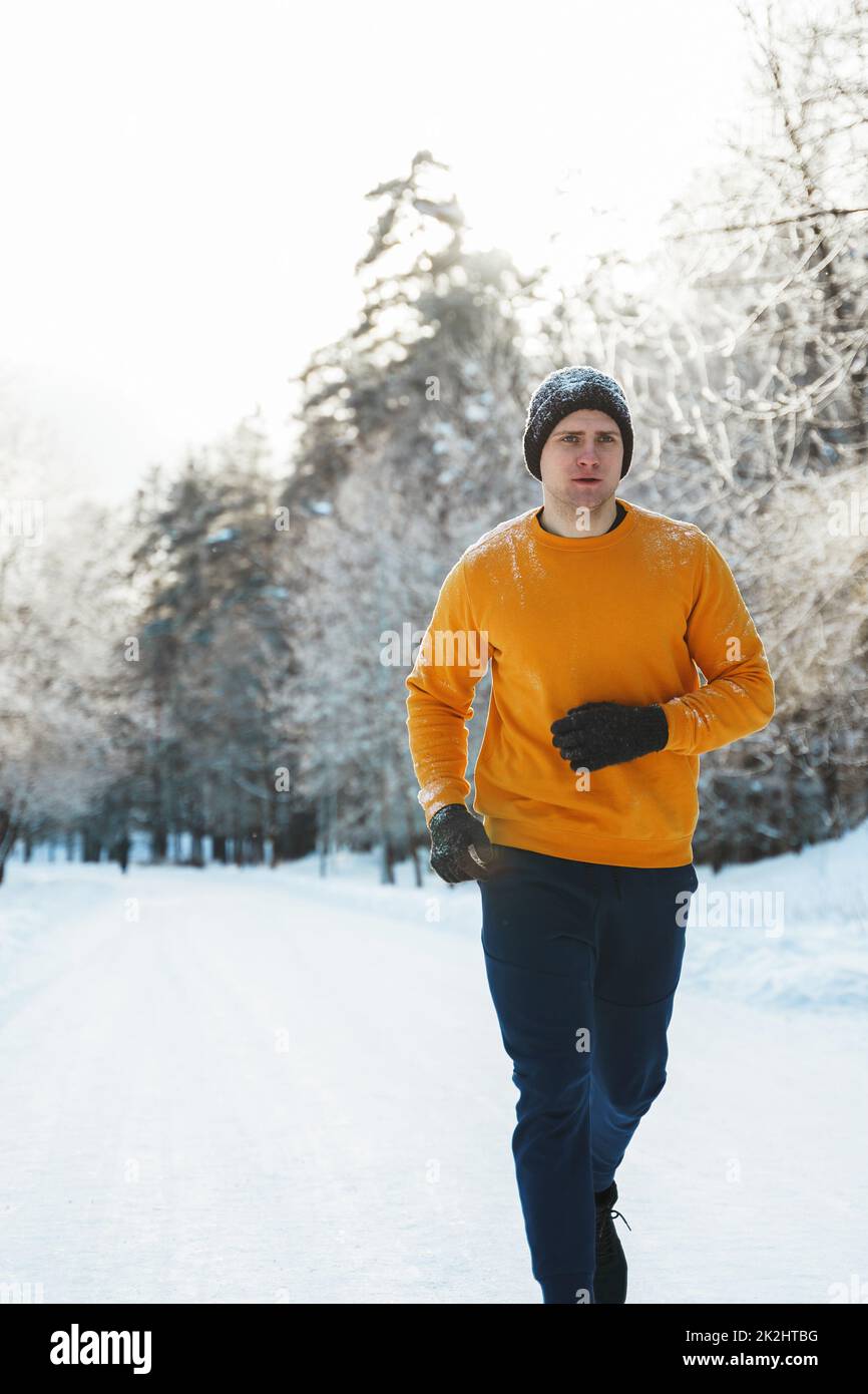 Jeune homme de jogging pendant son entraînement dans le parc d'hiver Banque D'Images