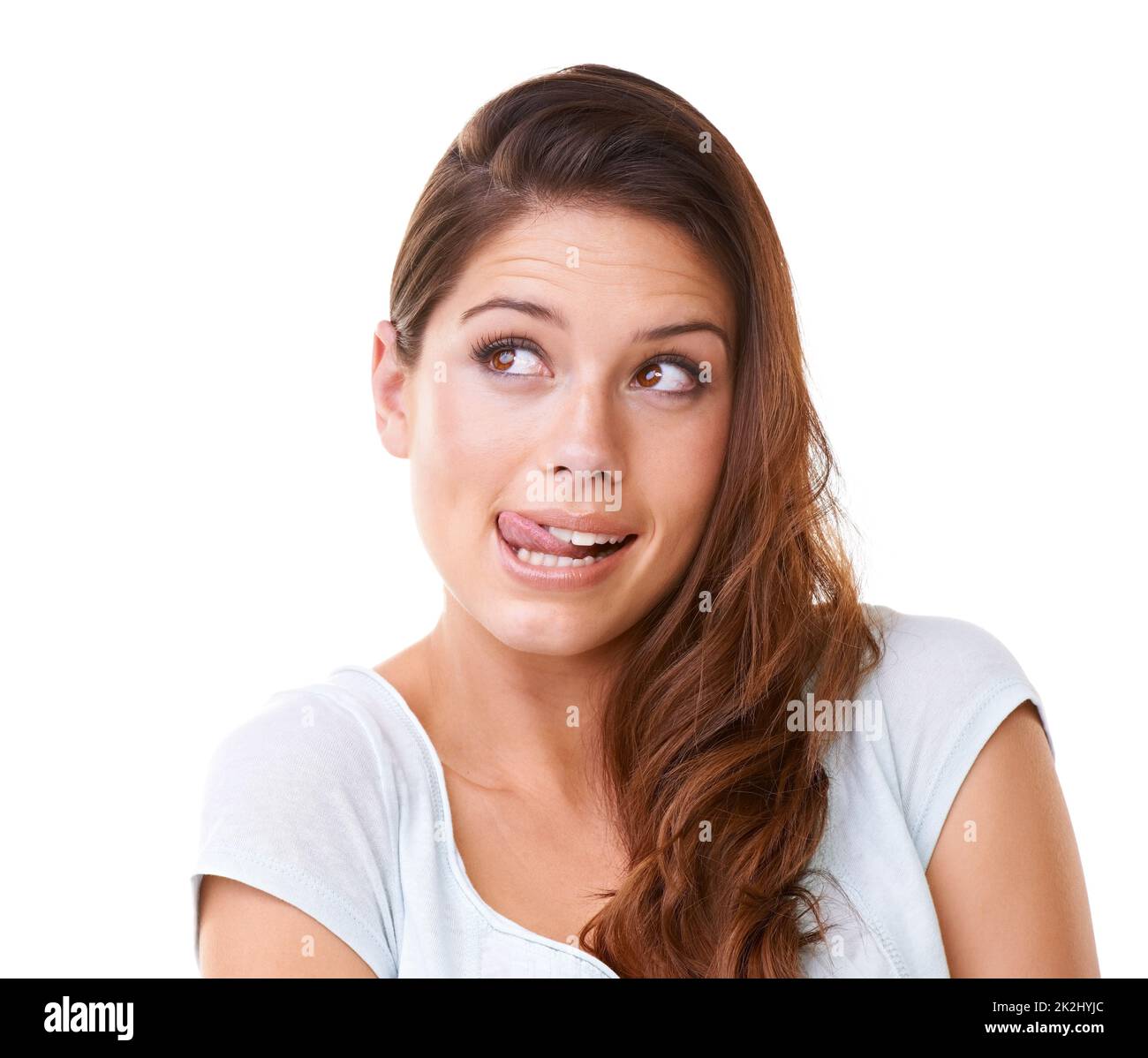 Sensation de peckish.Une magnifique jeune femme regardant sur les côtés tout en léchant ses lèvres. Banque D'Images