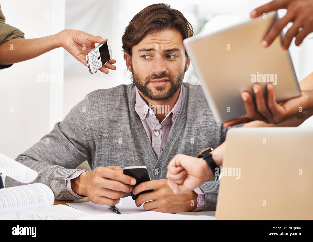 La délégation est essentielle pour éviter l'épuisement professionnel.Une courte photo d'un beau homme d'affaires avec des collègues lui demandant diverses choses. Banque D'Images