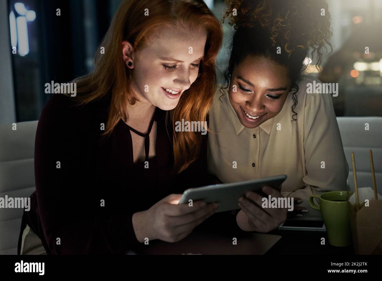 Partenaires en conception. Photo de deux jeunes designers travaillant tard au bureau. Banque D'Images