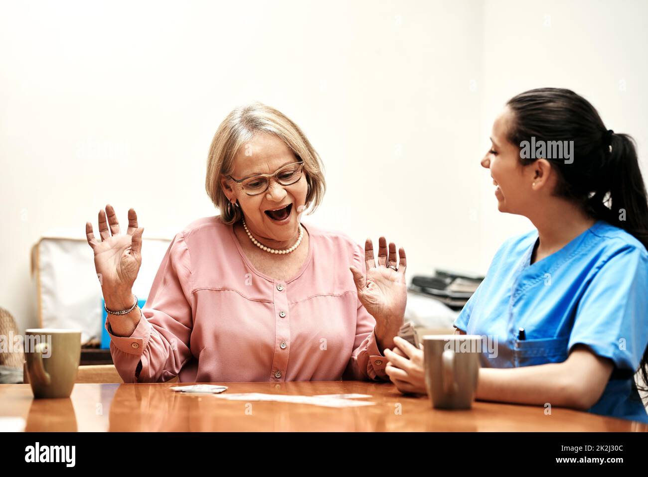 Je vous ai dit que je vous ai mieux parlé. Photo rognée d'une femme âgée jouant des cartes avec son soignant. Banque D'Images