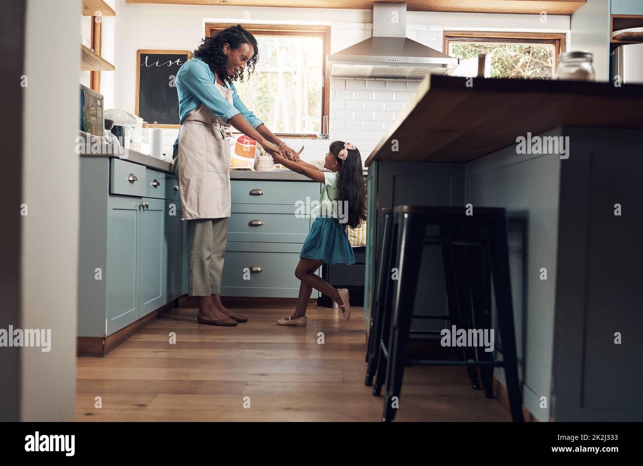 Je me maintiens avec l'amour de la famille. Photo d'une jeune femme dansant avec sa fille dans la cuisine à la maison. Banque D'Images