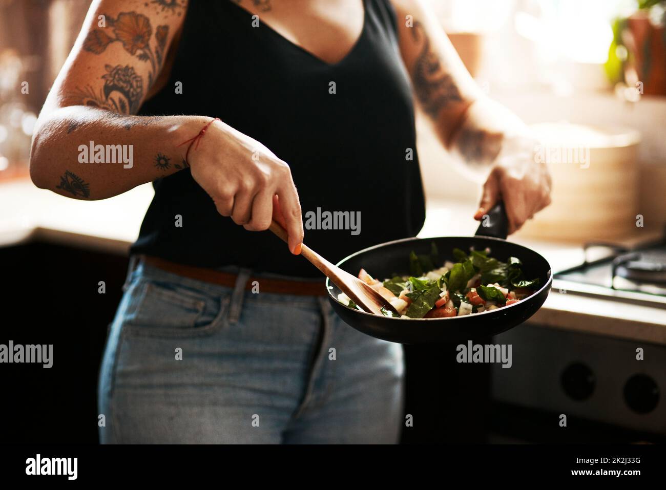 Sautés, le choix sain. Prise de vue courte d'une femme préparant un repas à la maison. Banque D'Images