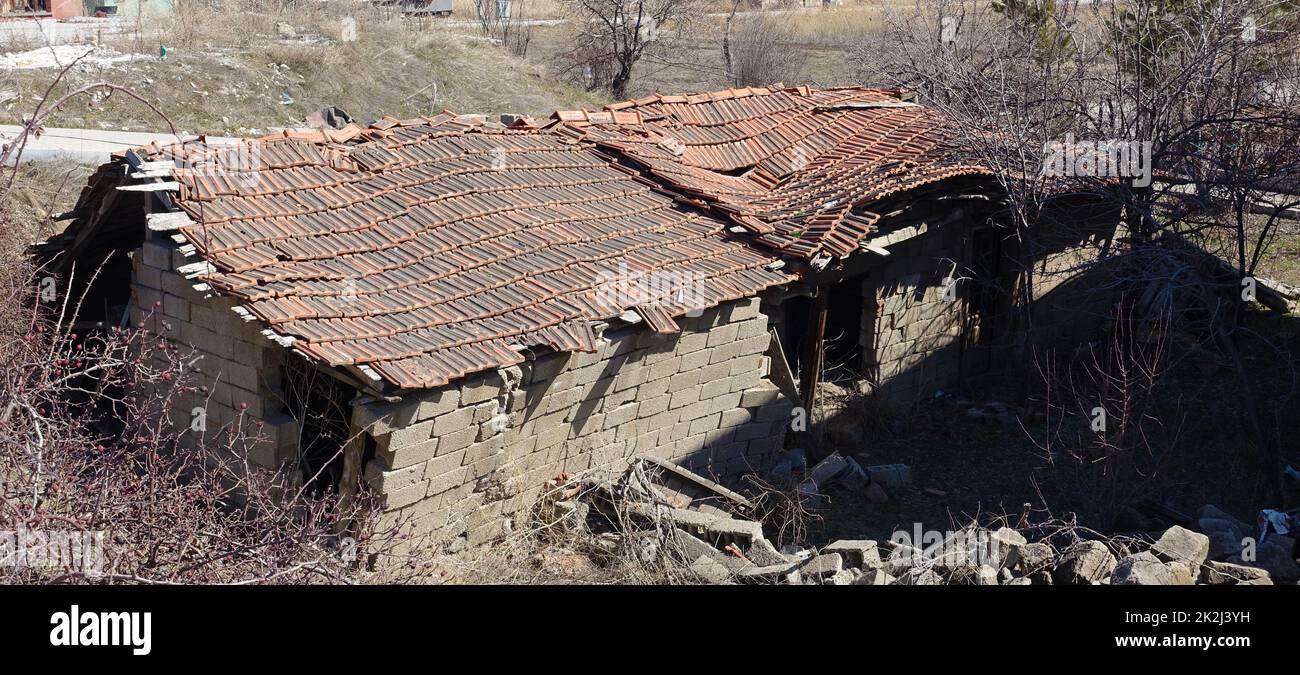 une vieille maison avec un toit tombant - une vieille maison sur le point de s'effondrer Banque D'Images