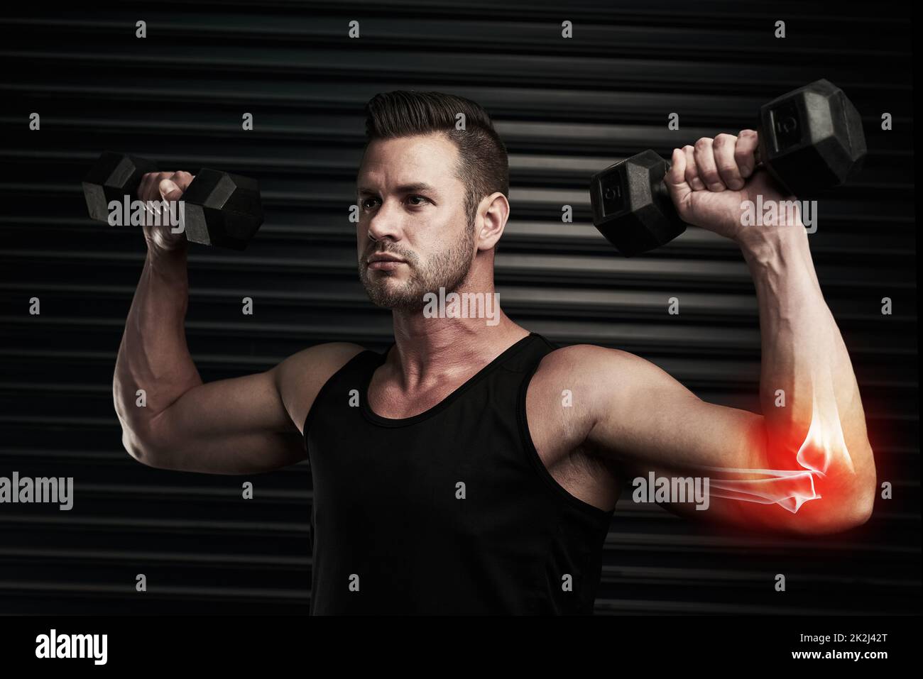 Élever son niveau de forme physique. Photo en studio d'un jeune homme sportif qui s'efforce avec des haltères. Banque D'Images