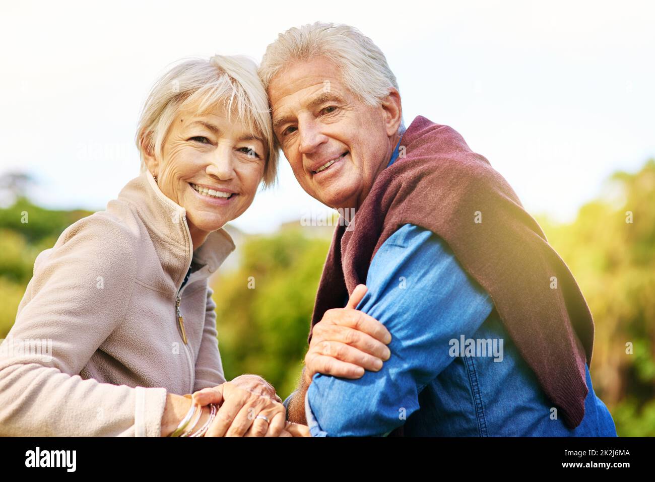 Le vrai amour est infini.Portrait d'un heureux couple senior assis sur un banc de parc. Banque D'Images