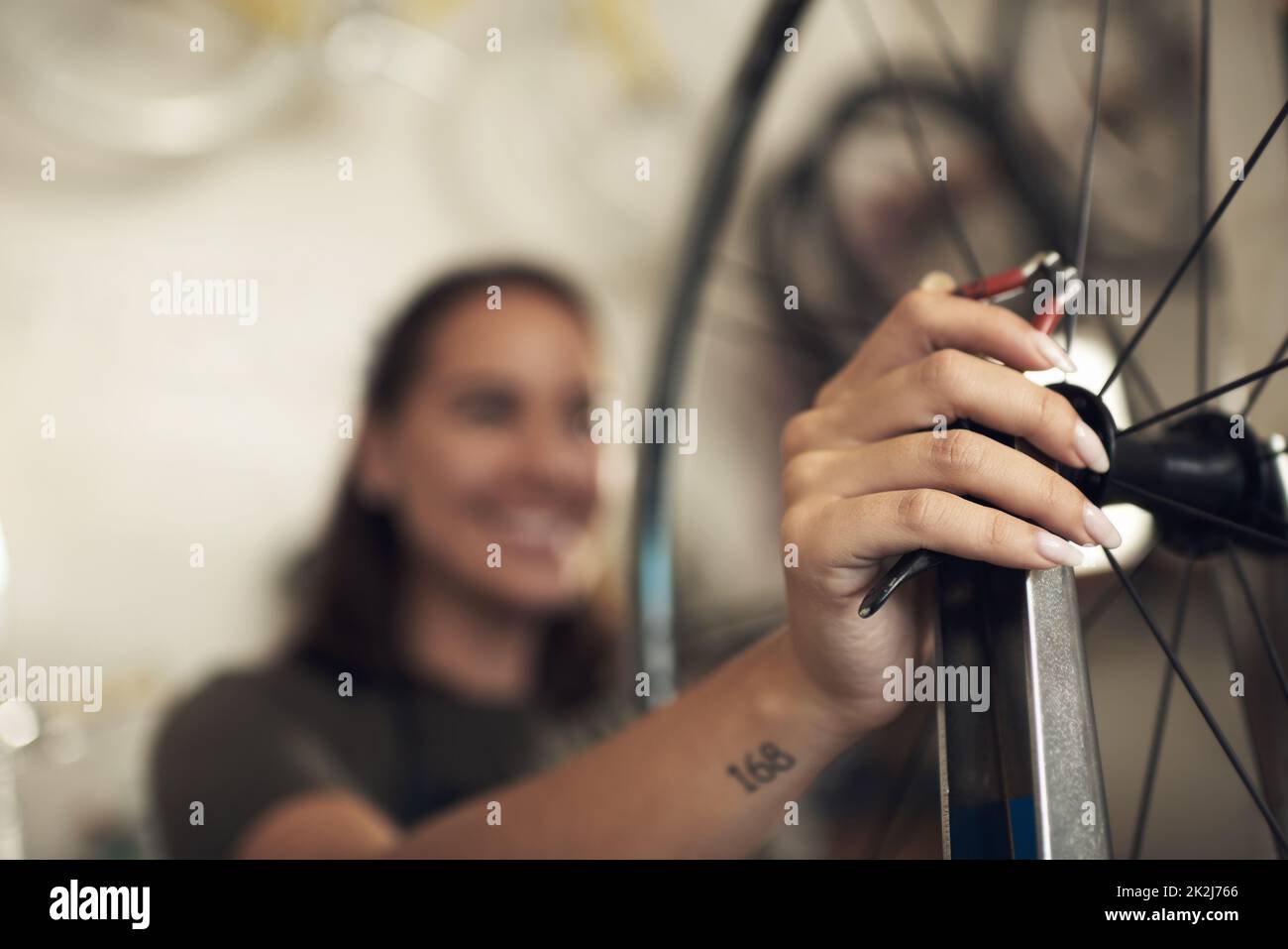 Dites Au revoir aux problèmes de vélo. Photo d'une femme non reconnaissable debout seule dans son atelier et en train de réparer une roue de vélo. Banque D'Images