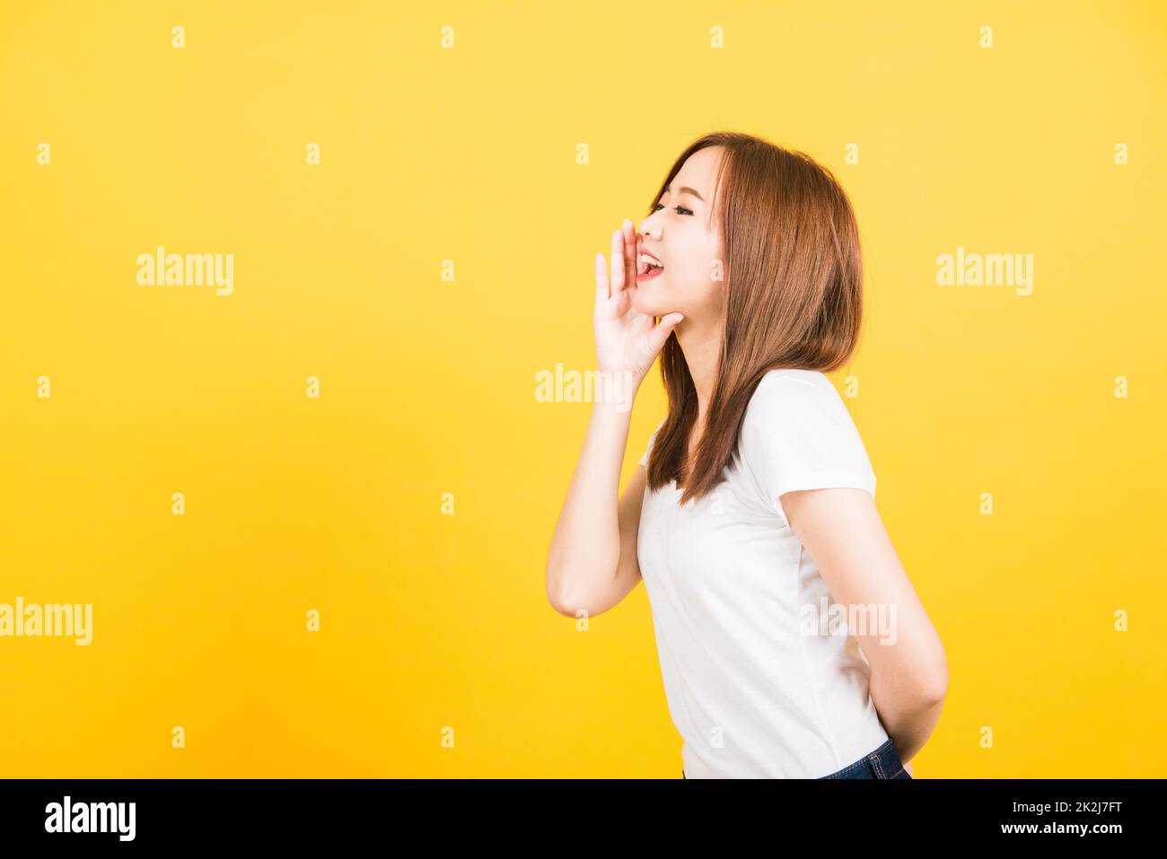 femme adolescente debout main sur la bouche parlant chuchotant secret rumeur Banque D'Images