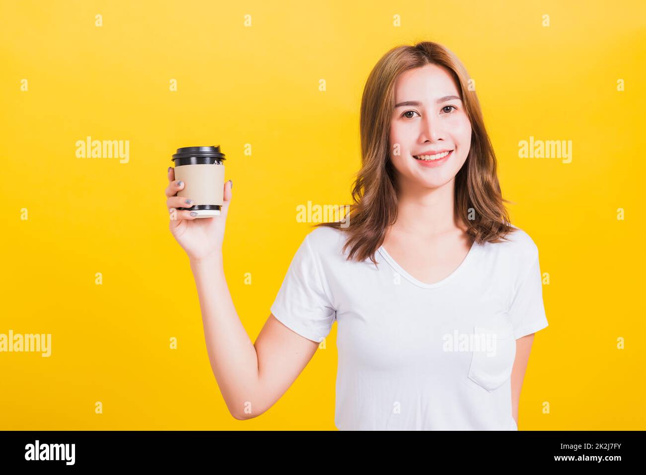 femme souriante tenant une tasse de papier à café à emporter Banque D'Images