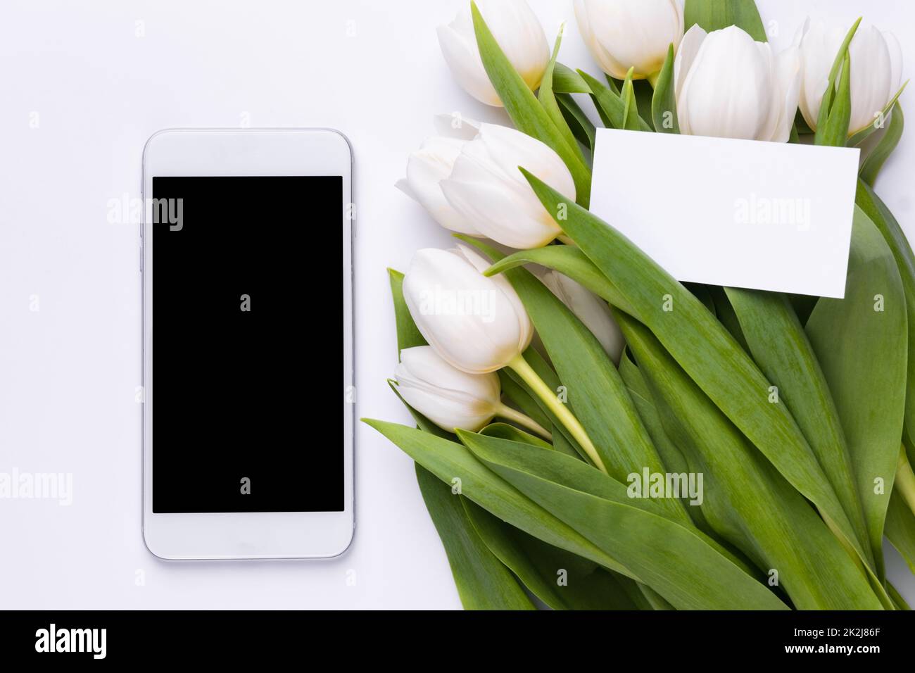 Maquette de smartphone, bouquet de tulipes avec carte vide. Maquette ou modèle de carte de vœux pour les fleurs Banque D'Images