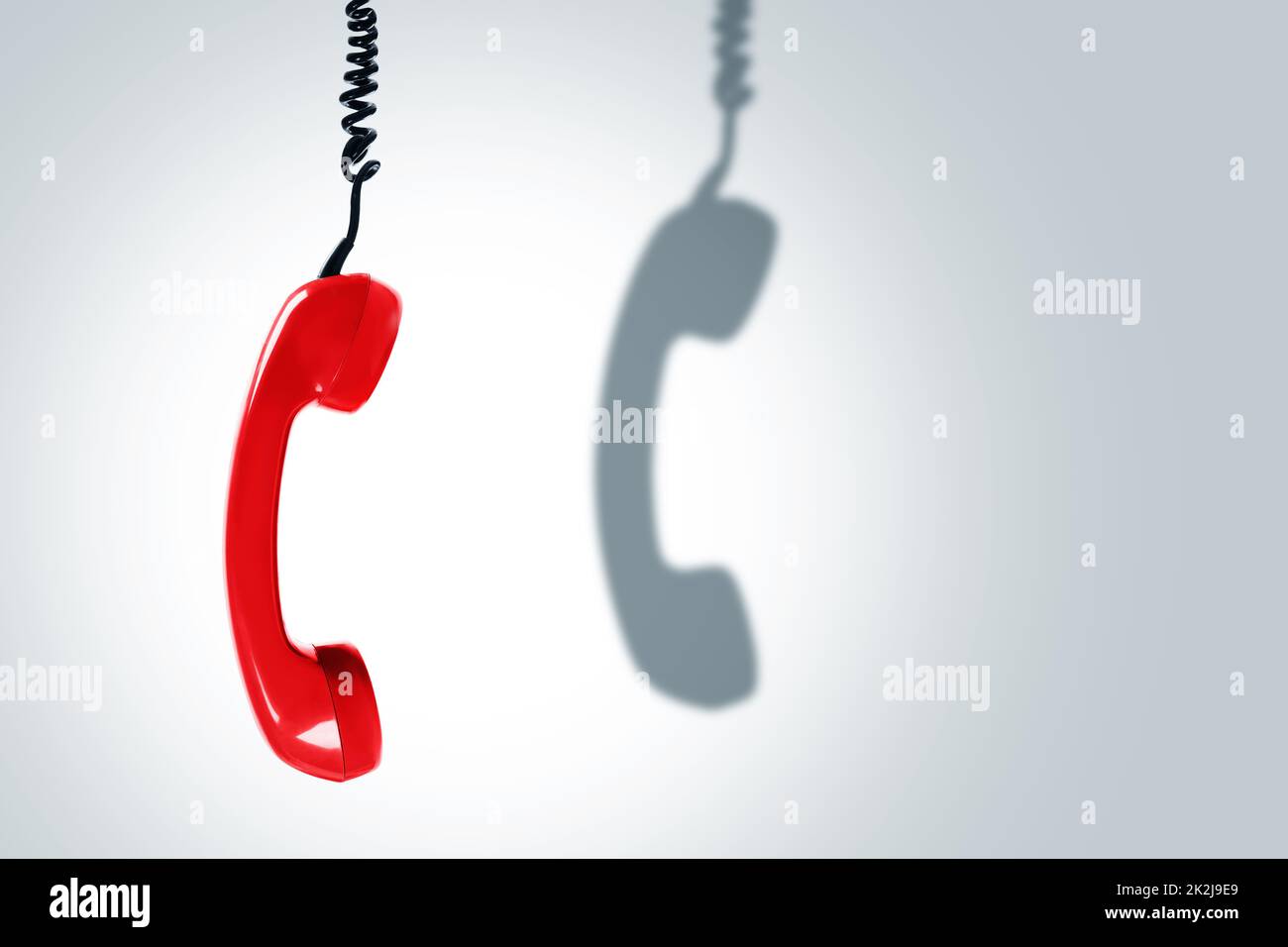 Combiné téléphonique rouge avec une ombre sombre. Concepts de hotline, d'assistance ou d'escroquerie téléphonique. Banque D'Images