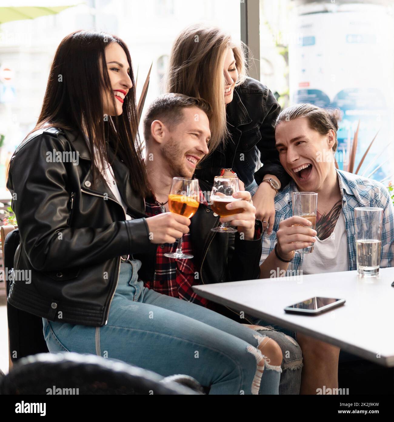 Un groupe d'amis boit de la bière et des cocktails dans un bar Photo ...