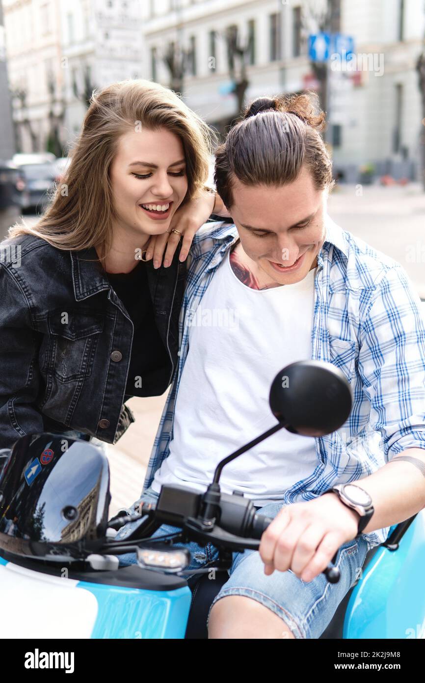 Couple élégant s'amusant en scooter électrique sur la rue de la ville Banque D'Images