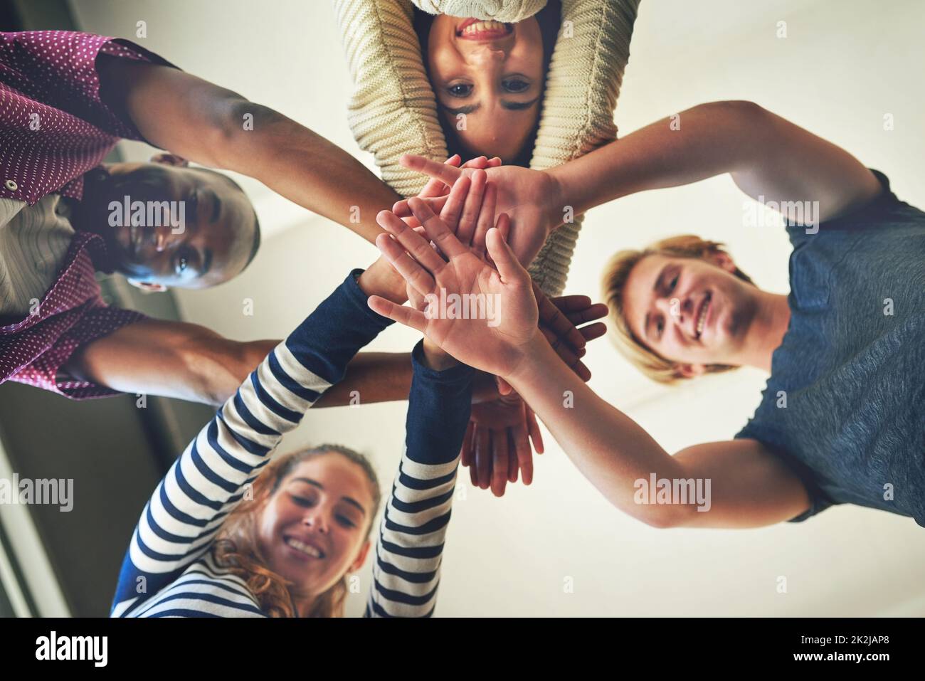 Ont été tous dans cette ensemble. Portrait d'un groupe d'étudiants amis qui accumulent leurs mains les uns sur les autres. Banque D'Images