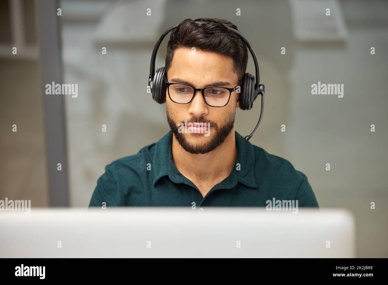 Appelez-nous parce que votre problème est notre problème aussi. Photo d'un homme d'affaires utilisant un ordinateur tout en travaillant dans un centre d'appels. Banque D'Images