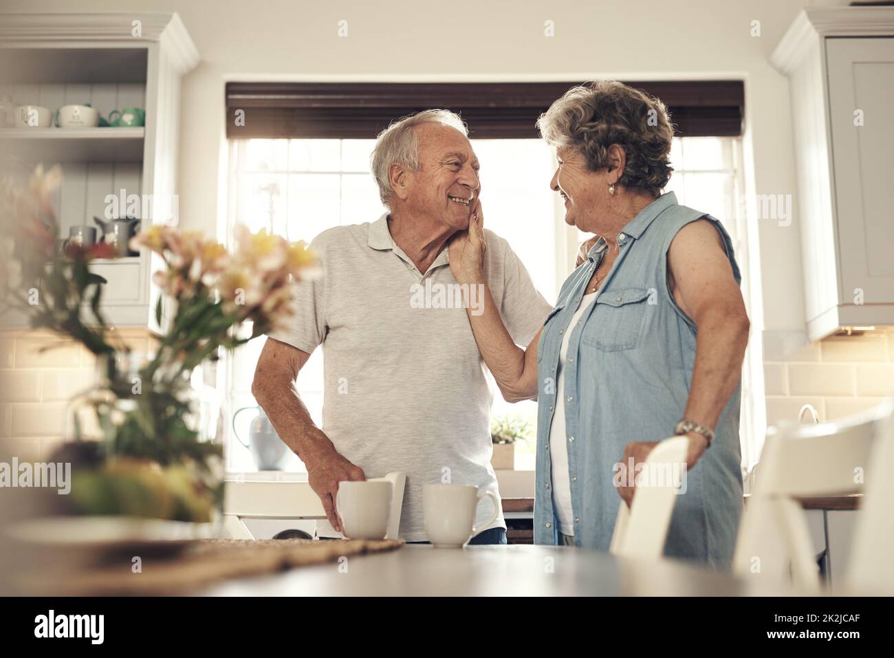 Chaque pression est aussi douce que jamais. Photo d'un couple senior prenant le petit déjeuner à la maison. Banque D'Images