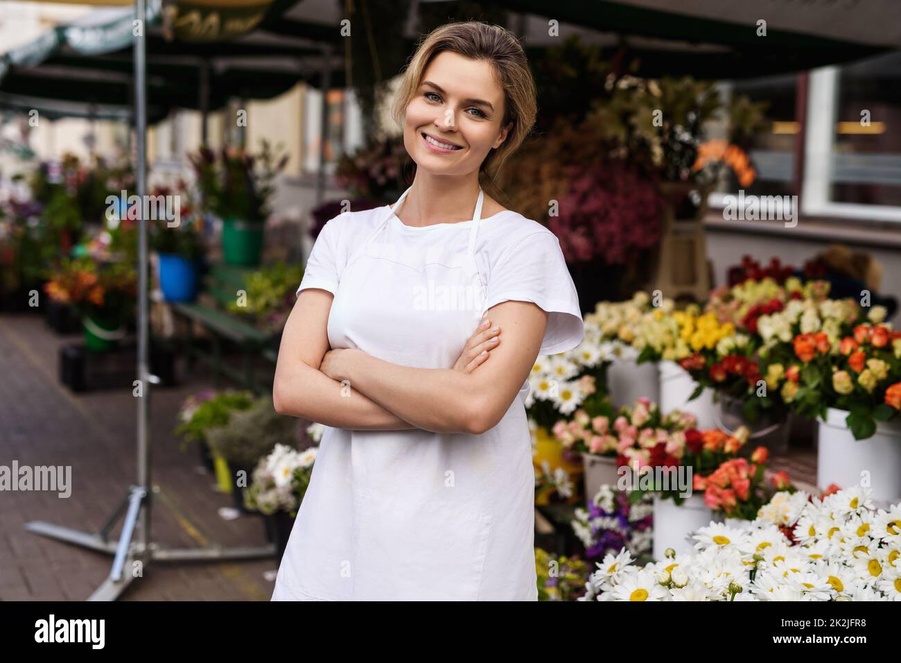 Belle femme fleuriste travaillant dans sa petite boutique de fleurs Banque D'Images