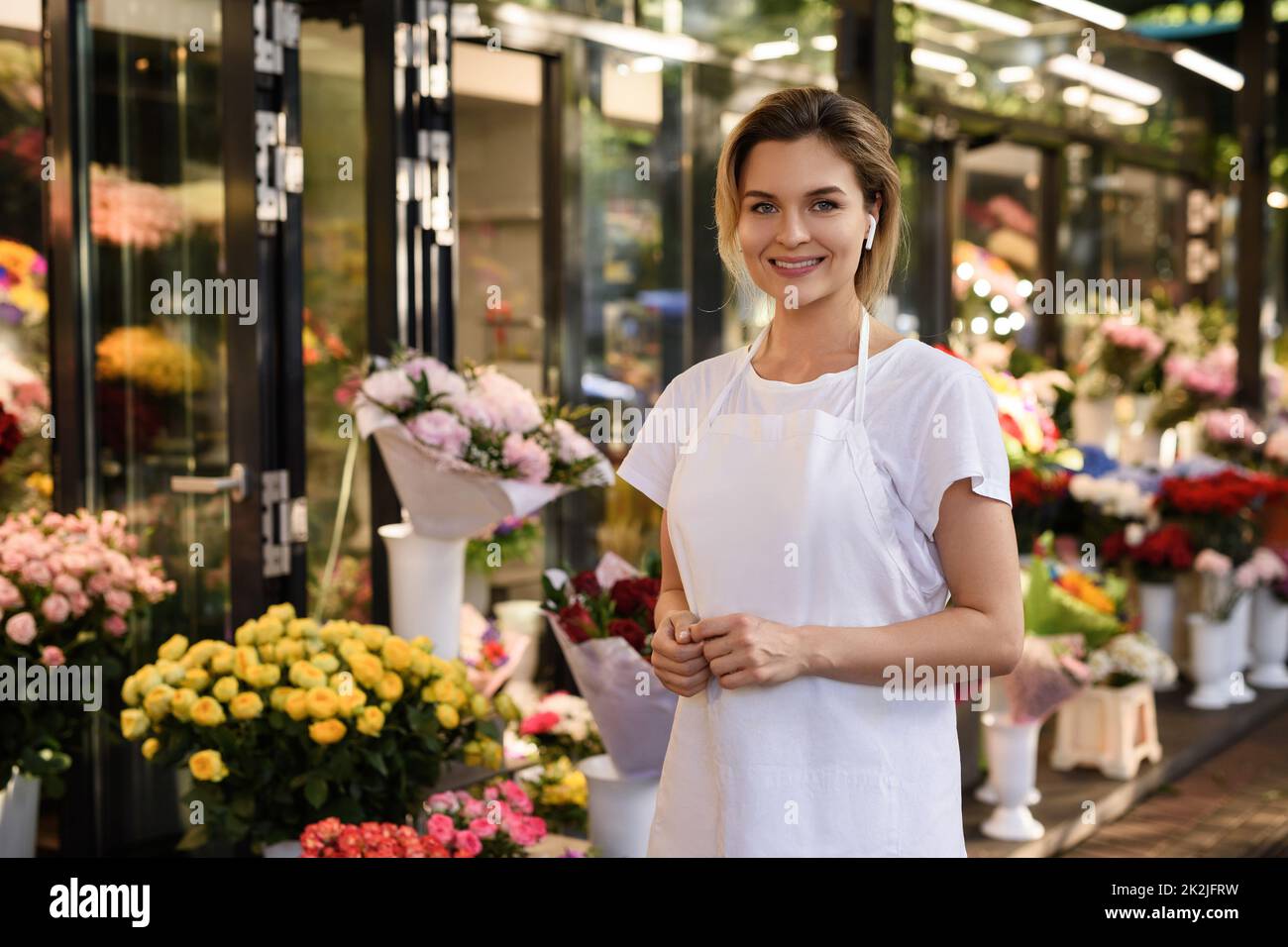 Belle femme fleuriste travaillant dans sa petite boutique de fleurs Banque D'Images