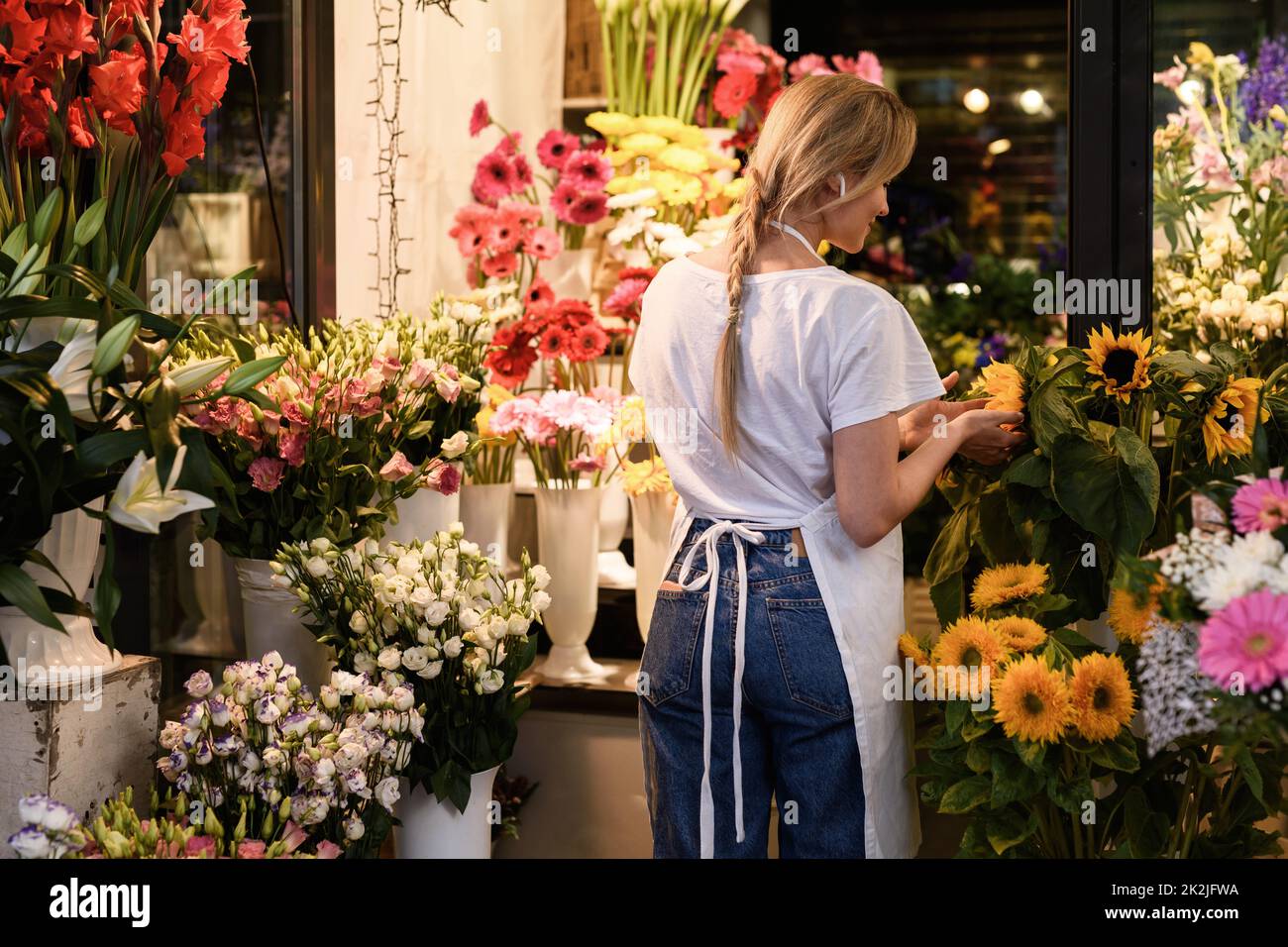Jeune fleuriste travaillant dans son petit fleuriste Banque D'Images