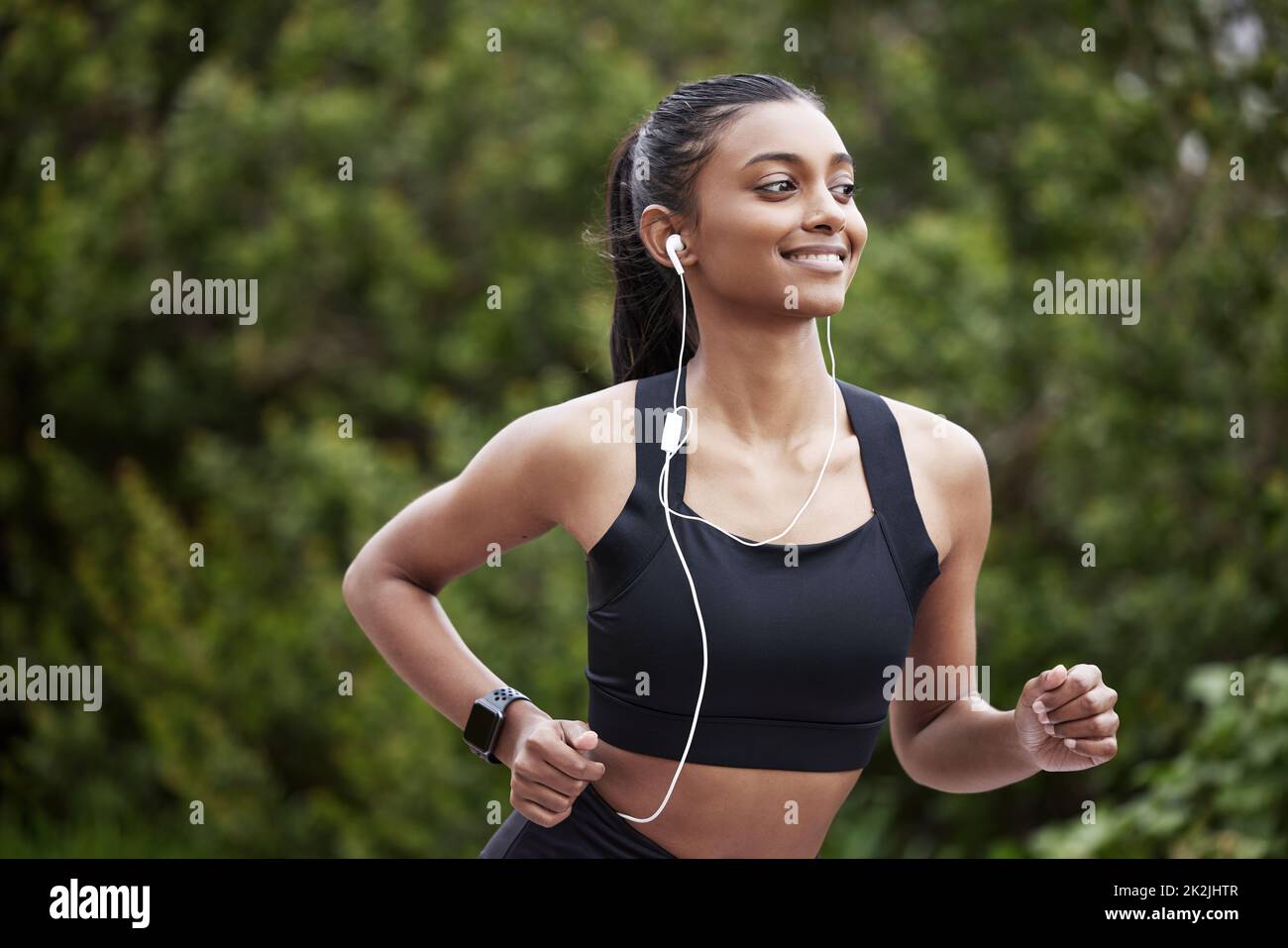 Je sais où la messagerie instantanée va. Prise de vue d'une jeune femme sportive portant des écouteurs pendant qu'elle court à l'extérieur. Banque D'Images