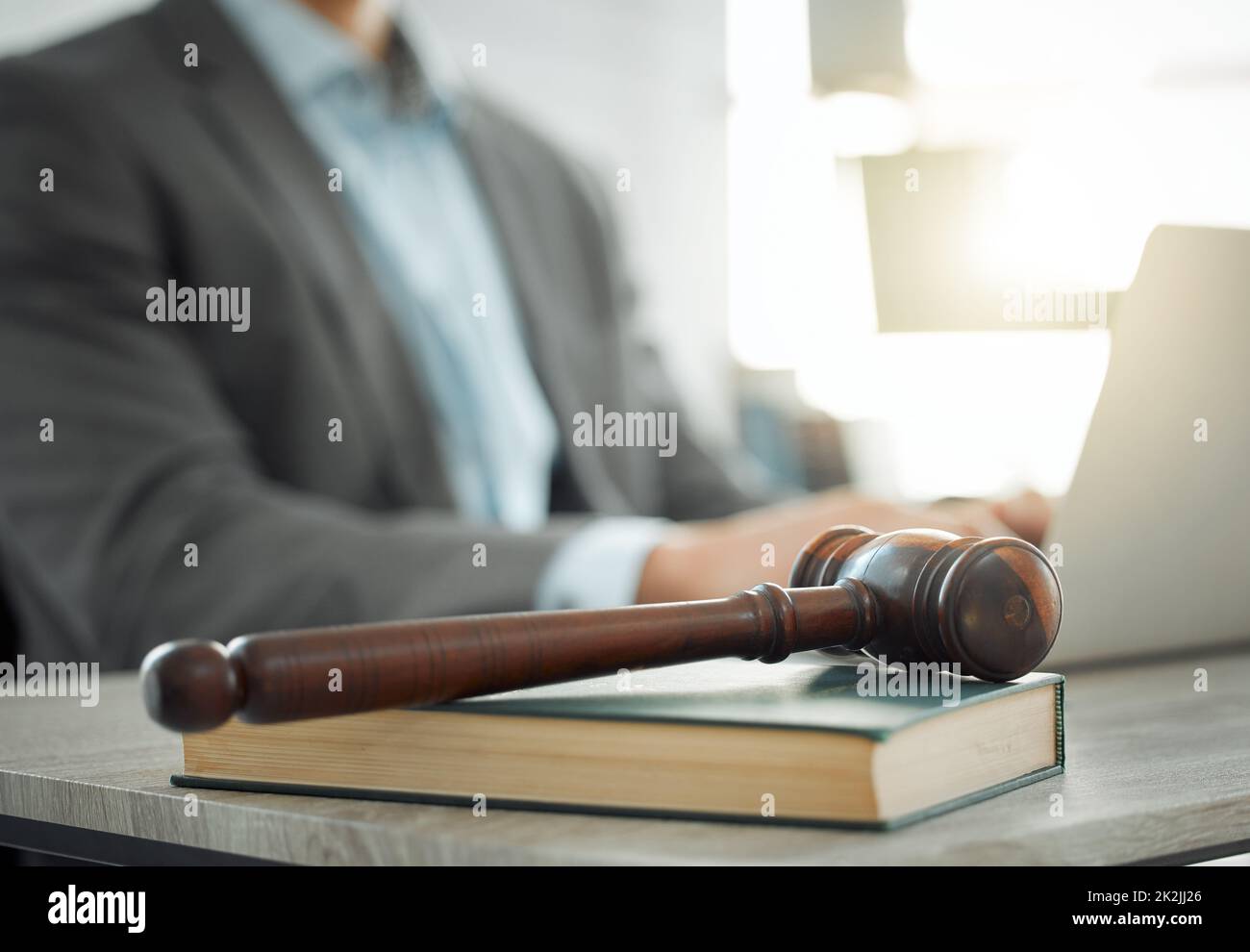 Brandissant le marteau de la justice. Photo d'un avocat travaillant sur son ordinateur portable. Banque D'Images