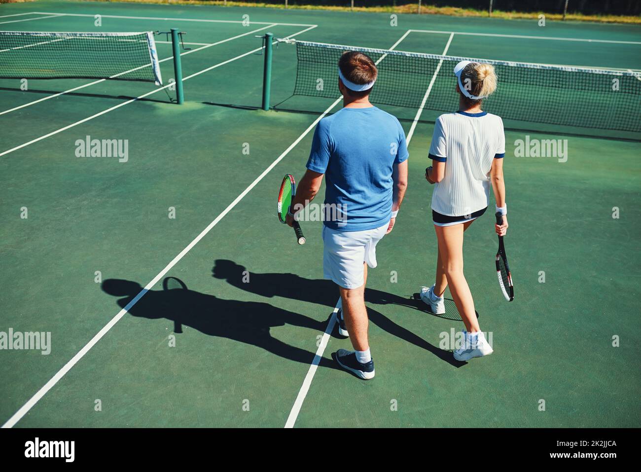 Nous sommes toujours à la hauteur du défi.Prise de vue en longueur de deux jeunes joueurs de tennis parlant tout en marchant ensemble à l'extérieur sur un court de tennis. Banque D'Images