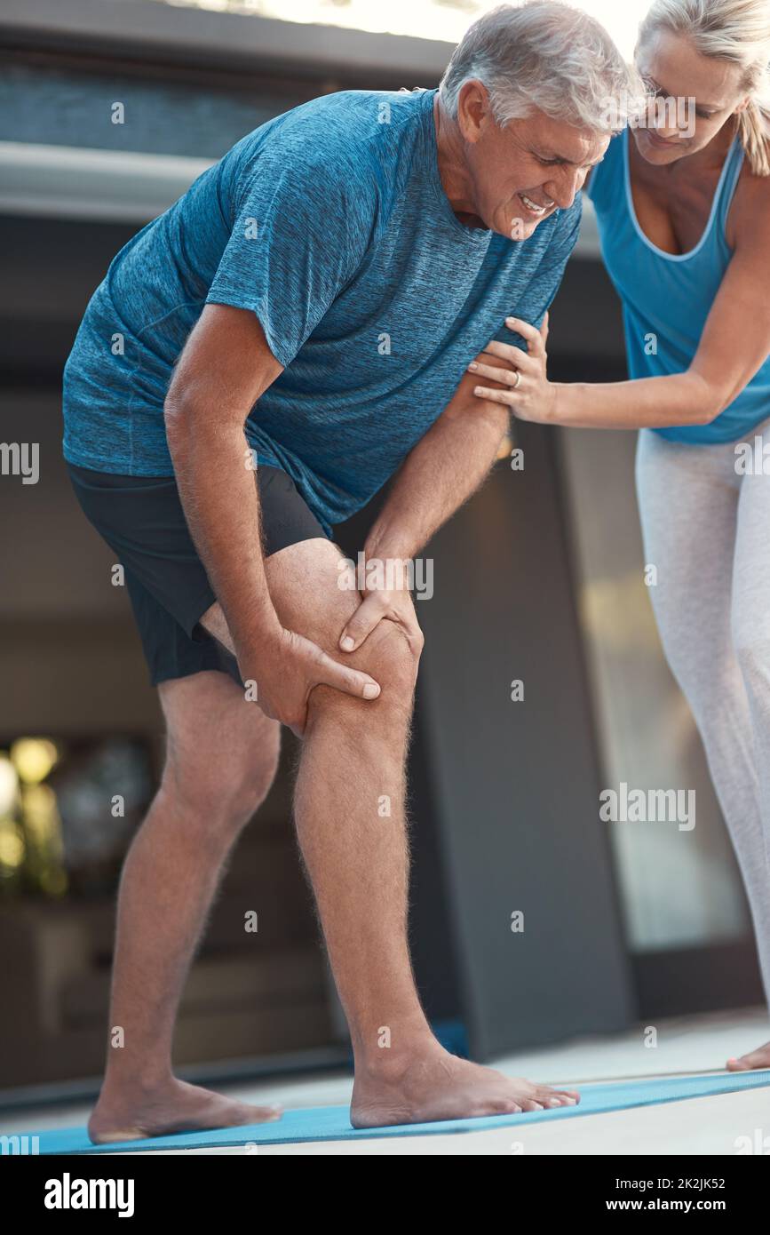 La douleur n'est que temporaire. Photo d'un homme mature qui attrapant sa jambe dans la douleur après un entraînement intense avec sa femme. Banque D'Images
