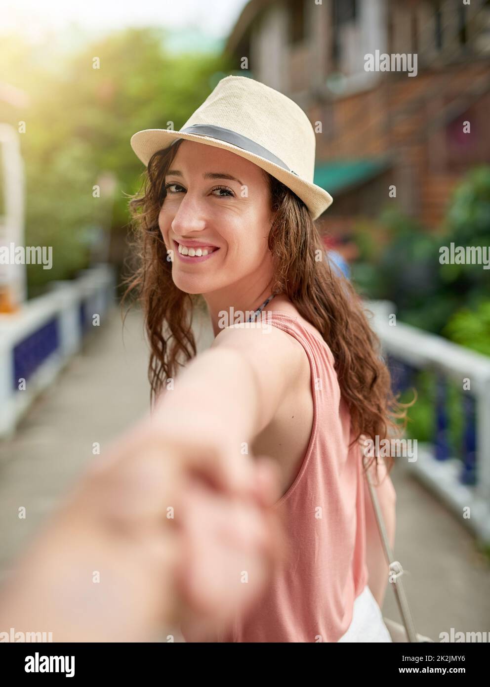 Explorons. Portrait d'une jeune femme en vacances, en conduisant son petit ami non identifiable par la main. Banque D'Images