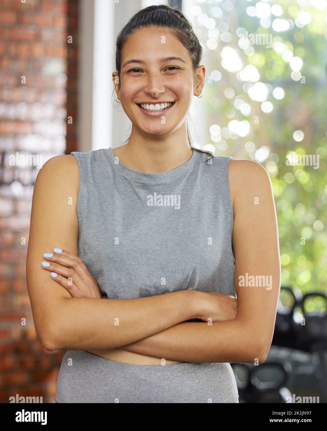 Organisez votre vie autour de vos rêves. Prise de vue d'une jeune femme posant et souriant dans une salle de sport. Banque D'Images