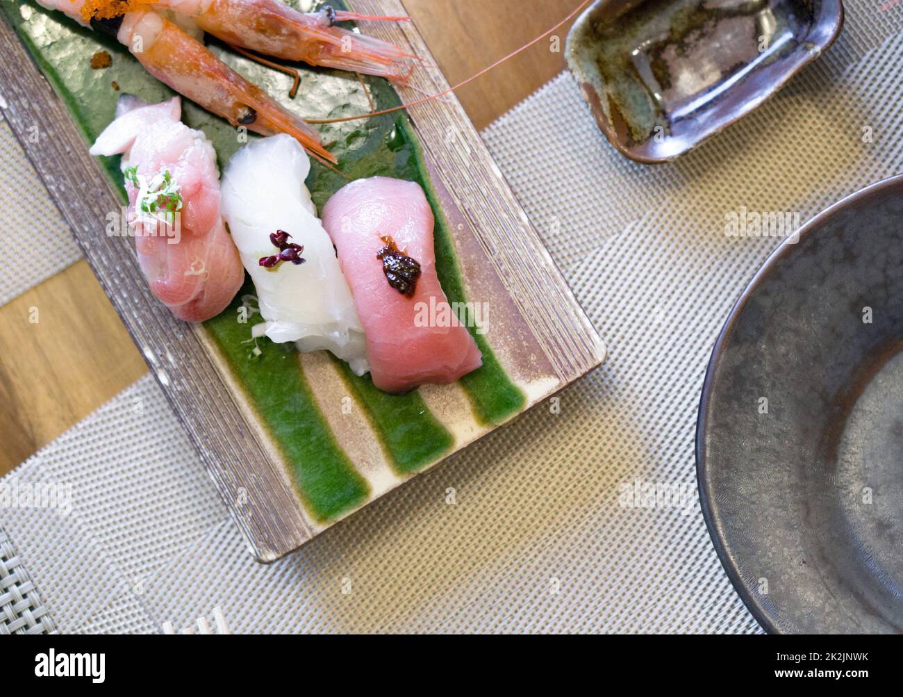 Le sushi est magnifiquement disposé sur une plaque en céramique. Buffet de cuisine japonaise. Choix du chef : crevettes, thon, Nodoguro et KINKI Banque D'Images
