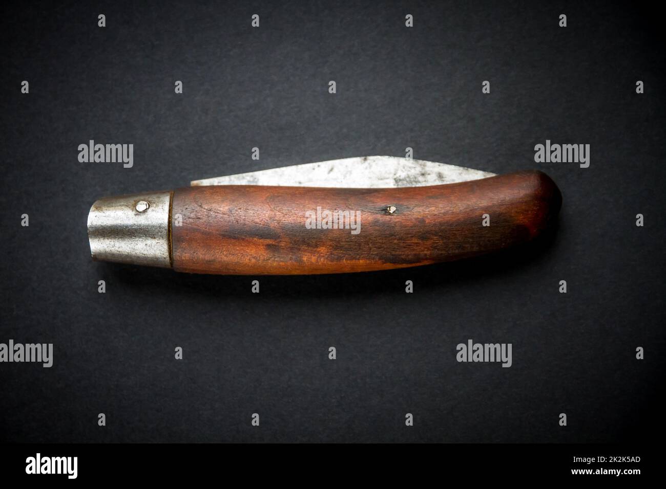Couteau de poche traditionnel en bois sur fond noir Banque D'Images