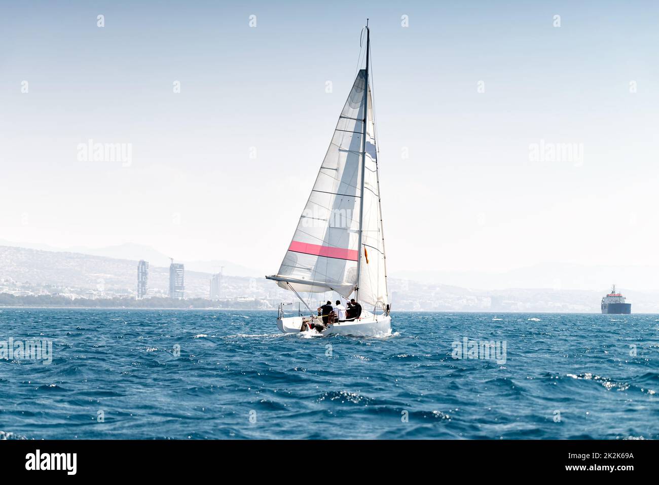 Voilier sport en mer calme, Limassol en arrière-plan Banque D'Images