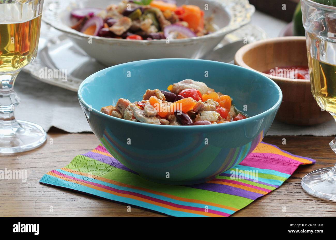 Ragoût de viande. Viande de bœuf rôtie. Viande de bœuf braisée. Viande lentement cuite avec des légumes servis dans un bol et des verres à vin Banque D'Images