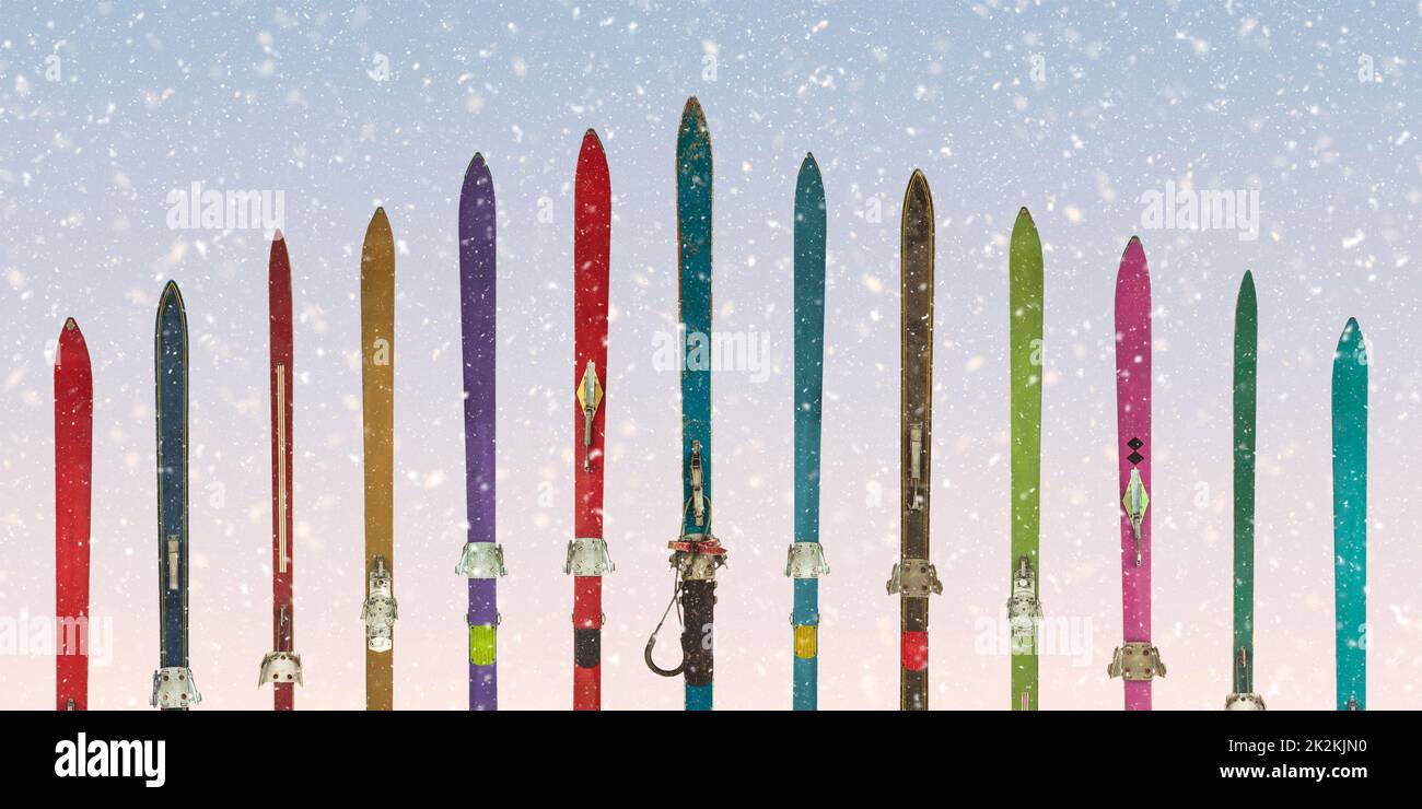 Une rangée de skis aux couleurs anciennes devant un ciel bleu enneigé Banque D'Images