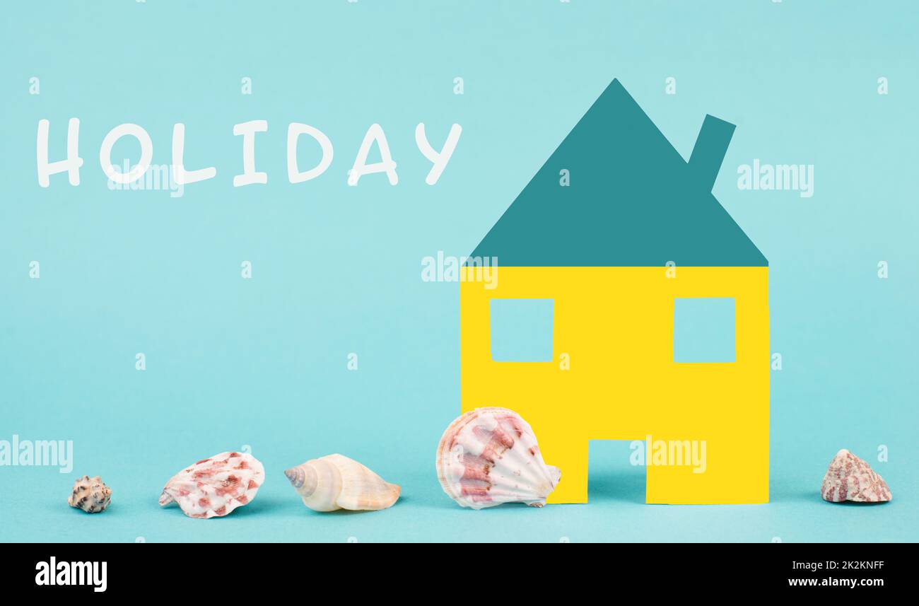 Maison blanche sur fond bleu avec coquillages, réservation d'un appartement, hôtel ou salon pour les vacances, vacances en été sur la plage, espace copie pour le texte Banque D'Images