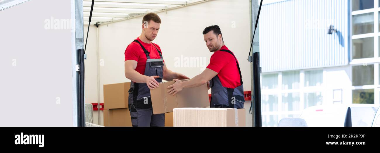 Jeunes hommes empiler les boîtes en carton dans un camion en mouvement Banque D'Images