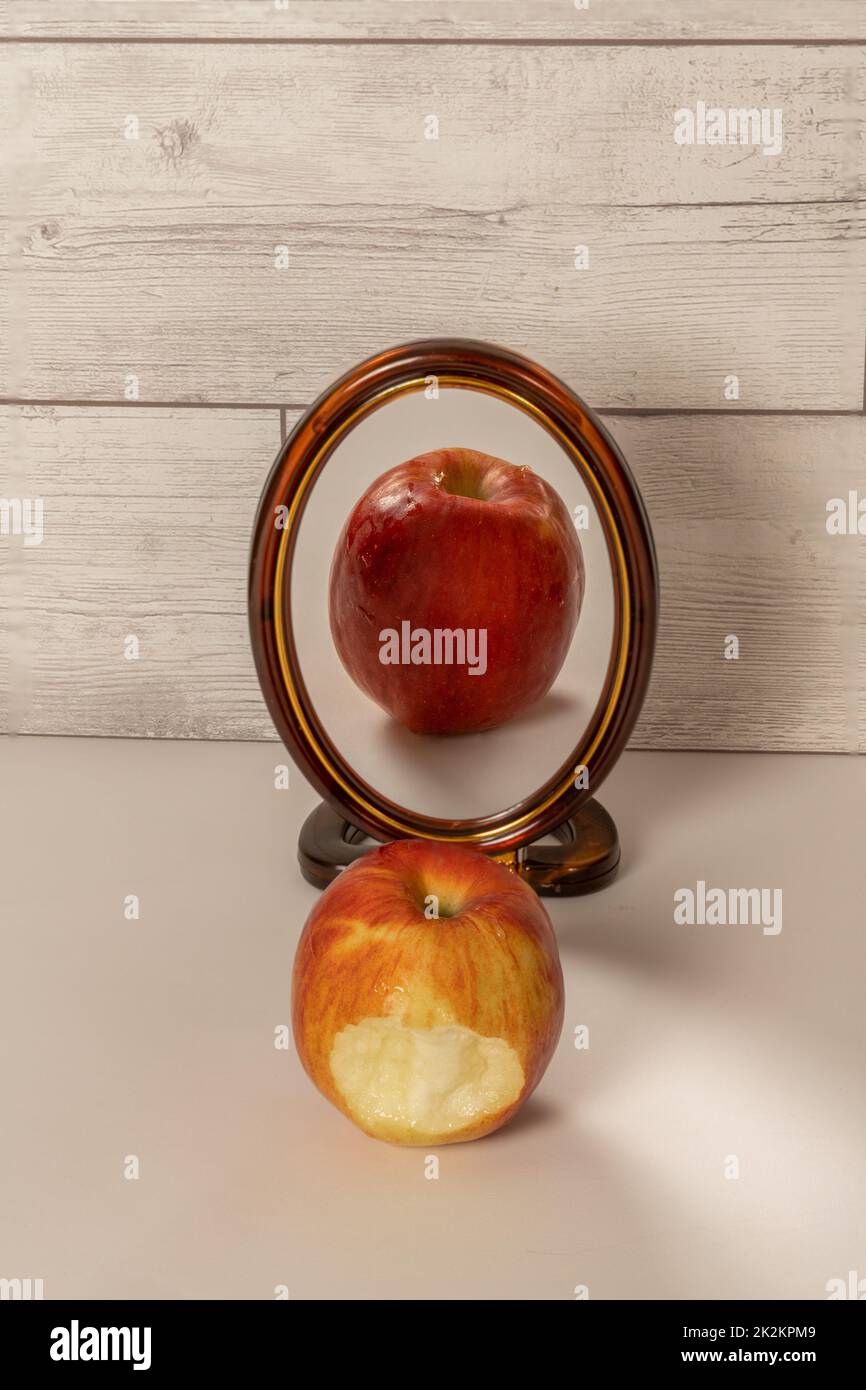une pomme rouge mordue se reflète dans un miroir Banque D'Images