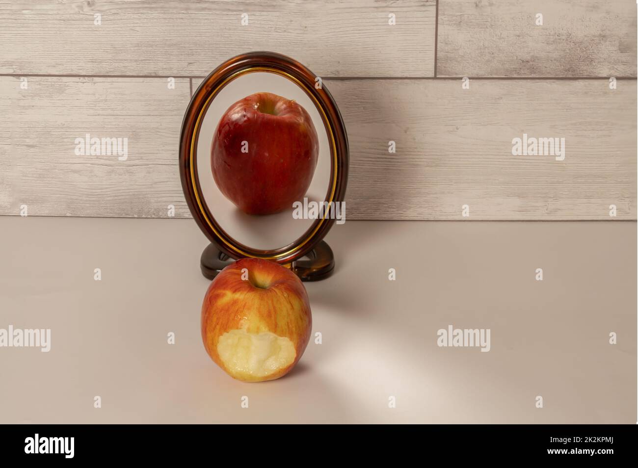 une pomme rouge mordue se reflète dans un miroir Banque D'Images