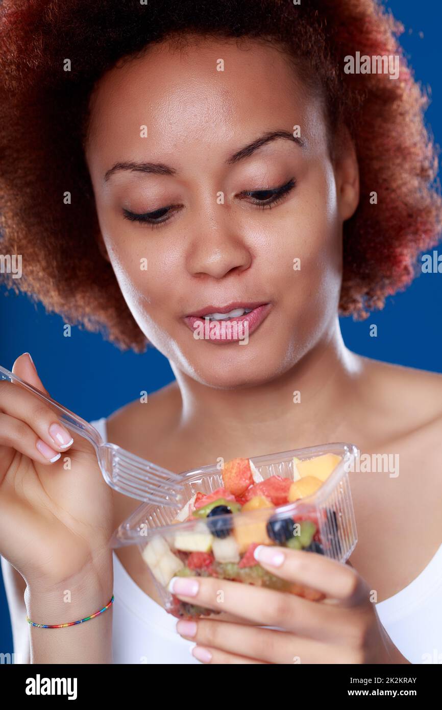 Jeune femme noire mangeant une salade de fruits frais saine Banque D'Images