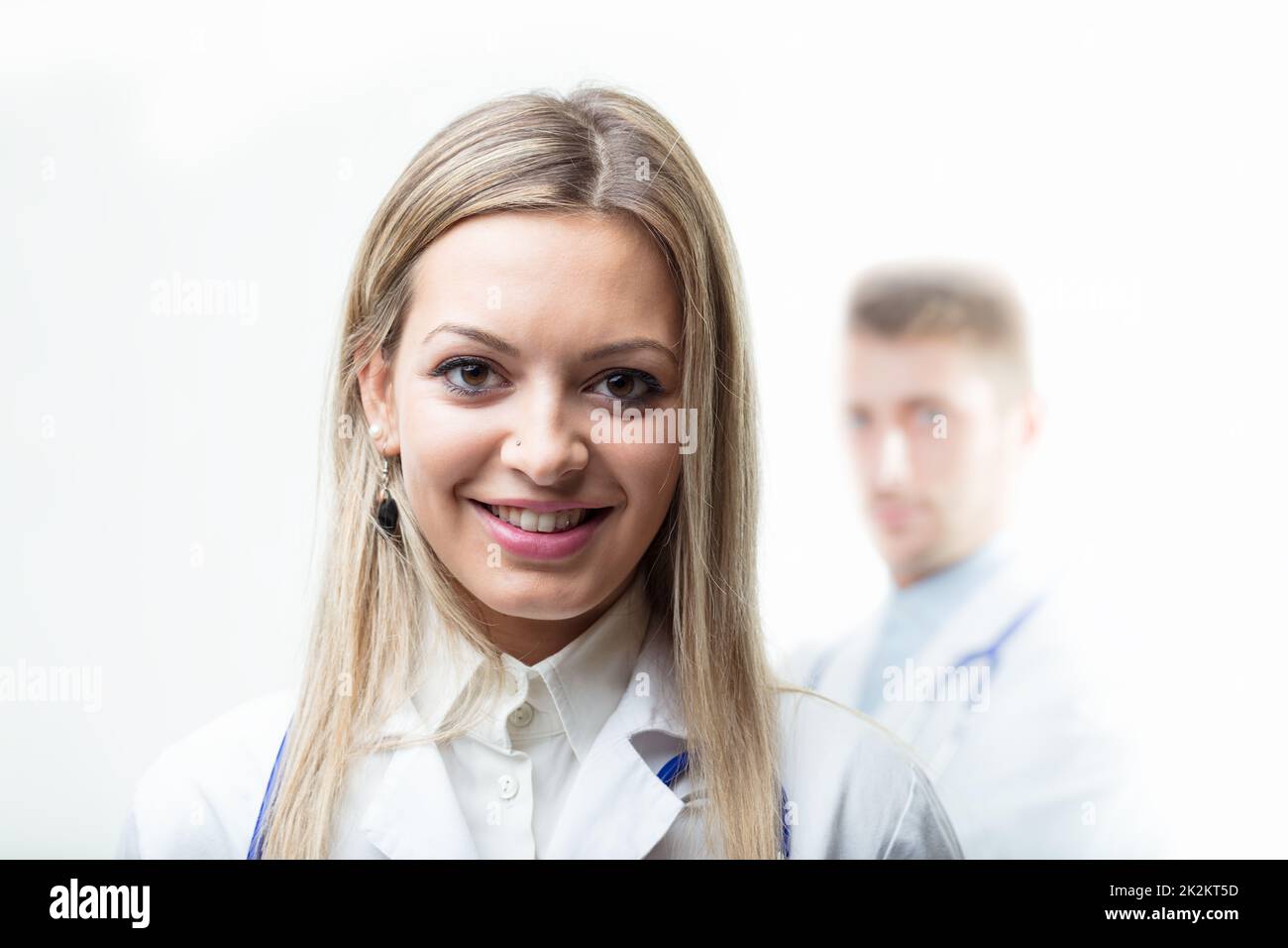 Docteur avec stéthoscope autour de son cou souriant à la caméra Banque D'Images
