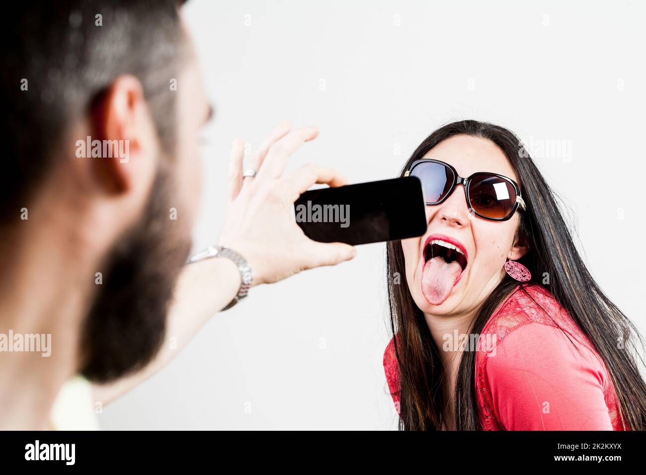 couple ravi de prendre des photos et des selfies mobiles Banque D'Images
