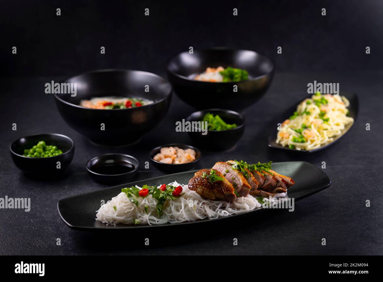 Divers plats de cuisine asiatique avec différents types de nouilles et de riz aux crevettes, canard, légumes et sésame noir Banque D'Images