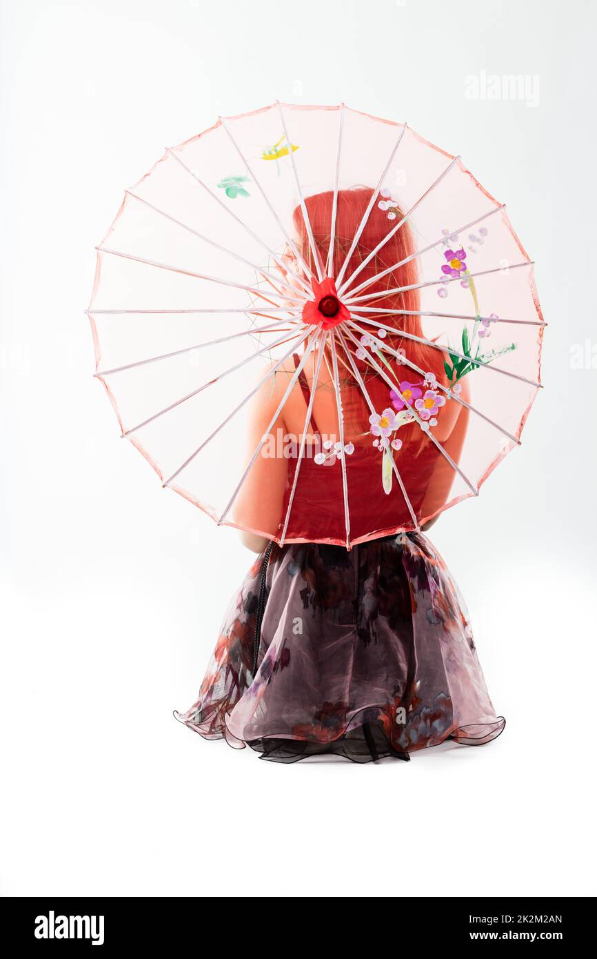 jeune danseur derrière un parapluie chinois rouge Banque D'Images