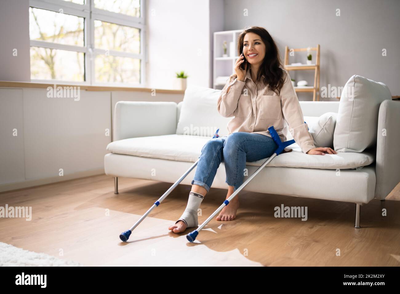 Femme atteinte aux jambes avec des béquilles Banque D'Images